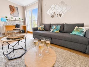 a living room with a couch and two tables with wine glasses at La Parenthèse Loggia - Calme & proche Disney in Champigny-sur-Marne