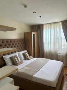 a bedroom with a large bed with two pillows on it at Davao Cozy Condo unit 1 in Davao City