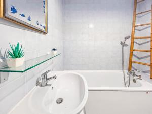a white bathroom with a sink and a bath tub at La Parenthèse Loggia - Calme & proche Disney in Champigny-sur-Marne +15 photos