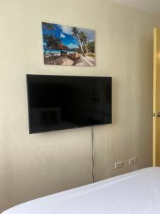 a flat screen tv hanging on a wall at Davao Cozy Condo unit 1 in Davao City