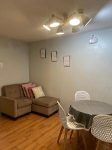 a living room with a couch and a table and chairs at Davao Cozy Condo unit 1 in Davao City