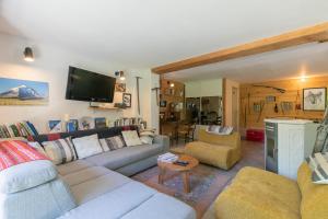 a living room with a couch and a tv at Les Rochas - Duplex pour 7 personnes in Champcella