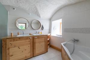 a bathroom with a sink and a tub and a mirror at Les Rochas - Duplex pour 7 personnes in Champcella +7 photos