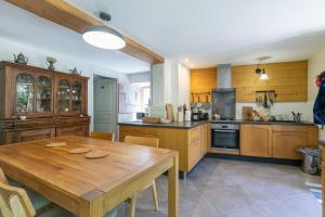a large kitchen with a wooden table and a table sidx sidx sidx at Les Rochas - Duplex pour 7 personnes in Champcella
