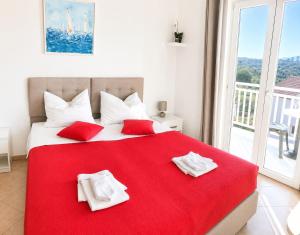 a bedroom with a large red bed with towels on it at Villa Bingo in Cavtat +30 photos