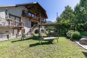 a couple of benches in the yard of a house at Les Rochas - Duplex pour 7 personnes in Champcella