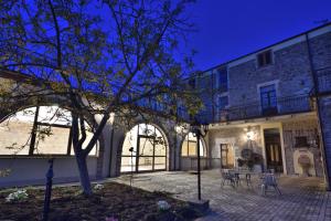 a building with a courtyard with tables and chairs at Villa Fozzi in Bonorva