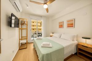 a bedroom with a bed with a green blanket at Jomarijo Boutique Rooms in Fuengirola