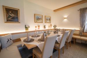a dining room with a long table and white chairs at HOTEL FONTANA in Sappada