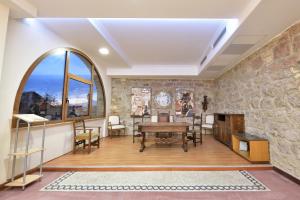 a living room with a table and a stone wall at Villa Fozzi in Bonorva