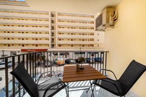 a balcony with a table and chairs and a building at Jomarijo Boutique Rooms in Fuengirola