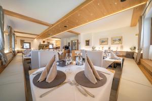 a dining room with white tables and napkins at HOTEL FONTANA in Sappada
