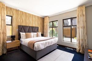 a bedroom with a large bed and windows at Alimama Spaces: Manson Mansion in Randjesfontein +72 photos