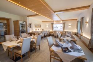 a dining room with tables and chairs in a restaurant at HOTEL FONTANA in Sappada