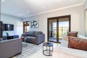a living room with two couches and a tv at Alimama Spaces: Manson Mansion in Randjesfontein