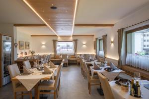 a dining room with tables and chairs in a restaurant at HOTEL FONTANA in Sappada