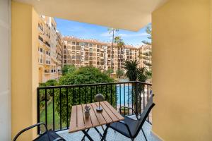a balcony with a table and chairs and a building at Jomarijo Boutique Rooms in Fuengirola