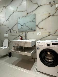 a bathroom with a sink and a washing machine at HODO in Orikum