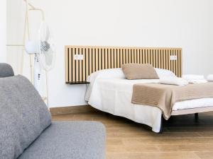 a bedroom with a bed and a fan and a couch at A Calexa Sarria nº2 in Sarria