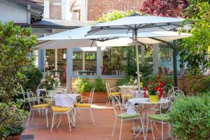 a patio with tables and chairs under an umbrella at La Villa in Siena