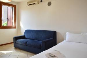 a blue chair and a bed in a room at Welc-ōM Conselve Matteotti in Conselve