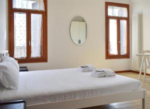 a white bed in a room with a mirror at Welc-ōM Conselve Matteotti in Conselve