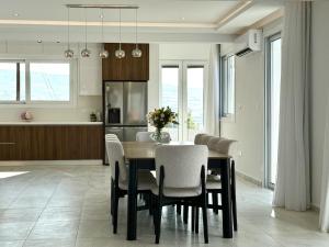 a kitchen and dining room with a table and chairs at Seaview Panorama Villa in Drousha