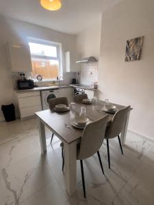 a kitchen with a wooden table and chairs in a room at 2 bedroom Large House For Contractors, And Family with a sofa bed in Shildon