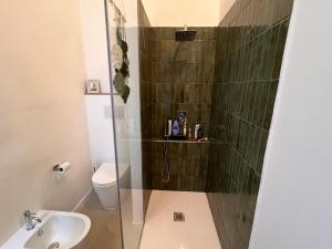 a bathroom with a shower with a toilet and a sink at Alessandra guest house in Alghero +22 photos