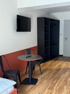 a room with a table and chairs and a tv at Penzión ZAYDA in Výrava