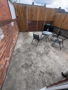 a patio with a table and chairs and a fence at 2 bedroom Large House For Contractors, And Family with a sofa bed in Shildon