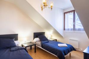 a bedroom with two beds and a window at Gîte Le Lot in Espalion