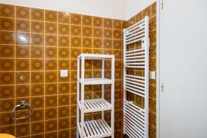 a bathroom with two white shelves and a tiled wall at Gîte Le Scaphandre in Espalion +16 photos
