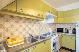 a kitchen with yellow cabinets and a sink at Gîte Le Lot in Espalion +12 photos