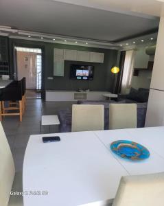 a kitchen and living room with a white table and chairs at BEGONVİL VİLLA in Belek
