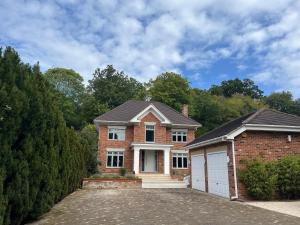 a brick house with a garage in front of it at The Welcome Haven - Cozy Studio with Patio & Free Parking in Chislehurst
