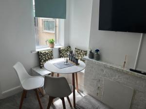 a living room with a table and chairs and a fireplace at Scorpio 1 in Burton upon Trent