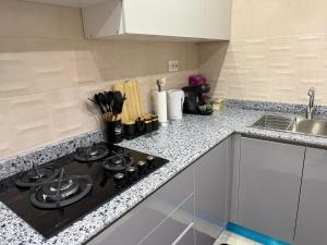 a kitchen with a stove and a sink at Appartement El-Chahed in Annaba +3 photos