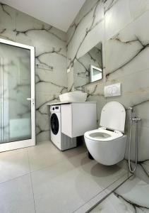 a bathroom with a toilet and a washing machine at HODO in Orikum +79 photos