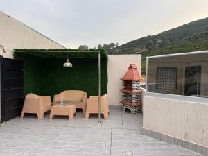 a patio with a table and chairs and a green wall at Appartement El-Chahed in Annaba