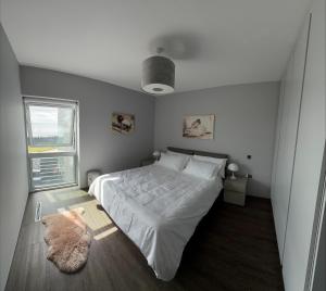 a bedroom with a white bed and a window at Slate House in Ballybunion +18 photos