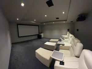 a conference room with white chairs and a screen at Slate House in Ballybunion
