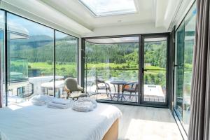 a bedroom with a bed and a balcony with a table at Capsule & Enesai Hotels Karakol in Karakol