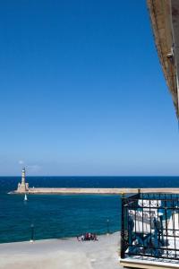a view of the ocean with a lighthouse in the distance at Suites Pandora in Chania Town