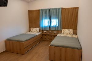 a bedroom with two beds and a window at Maria - Christina House in Soroni +25 photos