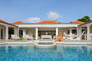 a villa with a swimming pool and a house at Seafacing Villas Apartments Rentals in Les Terres Basses