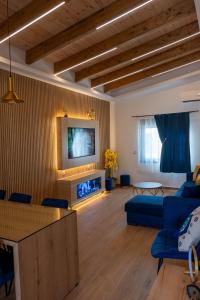 a living room with a blue couch and a tv at Maria - Christina House in Soroni