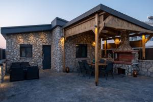 an outdoor patio with a stone building with a fireplace at Maria - Christina House in Soroni