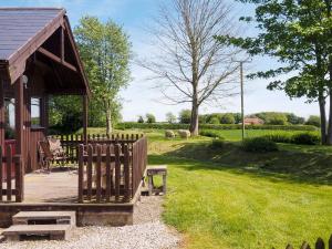 a wooden gazebo with a bench and a table at Robin Lodge - E4478 in Nawton