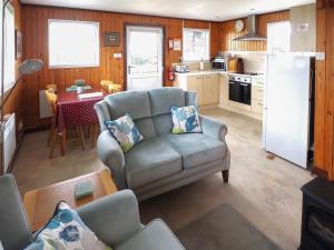 a living room with a couch and a kitchen at Robin Lodge - E4478 in Nawton